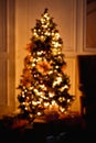Unfocused silhouette of a Christmas tree with blurred lights. Vertical frame New Year background