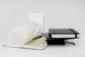 Unfold and closed small notebooks lie on top of each other. Fan open notepad with blank light beige pages. White back. Sketchbook Royalty Free Stock Photo