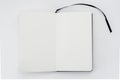 Unfold open notebook, book with blank white pages and black ribbon, bookmark on light back. Sketchbook. Top view Royalty Free Stock Photo
