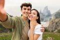 Unforgettable proposal on the beachfront. Happy couple embracing and taking selfie after engagement