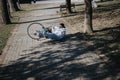 Unfortunate cyclist lying on ground after a bicycle accident in the park. Royalty Free Stock Photo