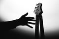 Unfulfilled dreams concept. Electric guitar on the shadow with man`s hand. Musician under the spotlight. Creative style photo wit Royalty Free Stock Photo