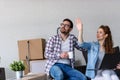 Ung couple moving in new home. Sitting and relaxing after unpacking. Looking something on laptop Royalty Free Stock Photo