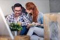 Ung couple moving in new home. Sitting and relaxing after unpacking. Looking something on laptop Royalty Free Stock Photo