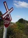 Unguarded rural railway tracks with rail crossing sign and stop sign Royalty Free Stock Photo