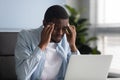 Unhappy african american businessman suffering from headache at work. Royalty Free Stock Photo