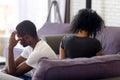 Rear view black couple sitting separately on couch not talking Royalty Free Stock Photo