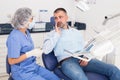 Unhappy american man in medical chair complains of toothache