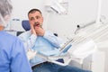 Unhappy american man in medical chair complains of toothache