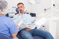 Unhappy american man in medical chair complains of toothache