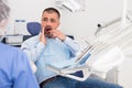 Unhappy american man in medical chair complains of toothache