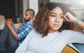 Unhappy, angry and stressed couple sitting on a sofa together after arguing. Young african american man and woman Royalty Free Stock Photo