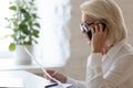 Unhappy angry 60 years old businesswoman talking on smartphone. Royalty Free Stock Photo