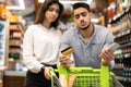 Unhappy Arabic Couple Having No Money Shopping Groceries In Supermarket Royalty Free Stock Photo