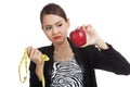 Unhappy Asian business woman diet with red apple and measuring Royalty Free Stock Photo