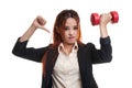 Unhappy Asian business woman thumbs down with dumbbells. Royalty Free Stock Photo