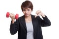 Unhappy Asian business woman thumbs down with dumbbells. Royalty Free Stock Photo