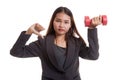 Unhappy Asian business woman thumbs down with dumbbells. Royalty Free Stock Photo