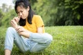 Unhappy asian female teen is sniffing her feet smell,hold her foot in her hand,stink legs,unpleasant smell,child girl with bad