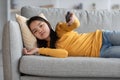 Unhappy asian kid laying on couch, watching TV Royalty Free Stock Photo
