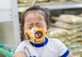 Unhappy Asian little child girl wears a beautiful mask