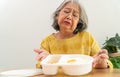 Unhappy Asian senior woman anorexia and say no to ready meals, Elderly home alone and bored food and no appetite Royalty Free Stock Photo