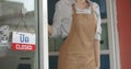 Unhappy woman small business owner changing doorplate from 