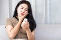 Unhappy Asian woman suffering from toothache, sore, swollen, and bleeding gums hand holding bottle of medidine