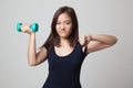 Unhappy Asian woman thumbs down with dumbbells. Royalty Free Stock Photo