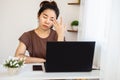 Asian woman tired her eyes from working on laptop screen