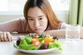 Unhappy asian women is on dieting time looking at broccoli on the fork. woman do not want to eat vegetables.