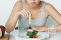 Unhappy asian women is on dieting time looking at broccoli on the fork. woman do not want to eat vegetables. Royalty Free Stock Photo