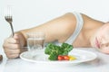 Unhappy asian women is on dieting time looking at broccoli on the fork. Royalty Free Stock Photo