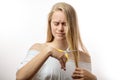 Frustrated young blonde woman having a problems with bad hair on white background Royalty Free Stock Photo