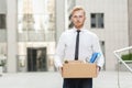 Unhappy bearded business man going out with cardboard, looking at camera and feeling looser.