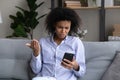 Unhappy biracial woman distressed by news on cellphone