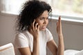 Unhappy biracial woman having unpleasant cellular call Royalty Free Stock Photo