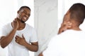 Unhappy Black Guy Suffering Neck Ache While Standing Near Mirror In Bathroom Royalty Free Stock Photo