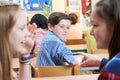 Unhappy Boy Being Gossiped About By School Friends In Classroom Royalty Free Stock Photo