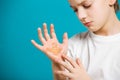 Unhappy boy in white clothes with adhesive plaster on his hand Royalty Free Stock Photo