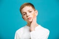 Unhappy boy in white clothes holding adhesive plaster on his che