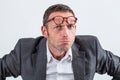 Unhappy businessman with eyeglasses on his forehead for suspicion Royalty Free Stock Photo