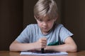 Unhappy child holding black crayon Royalty Free Stock Photo