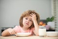 Unhappy child sit at table at home kitchen have no appetite. Caucasian toddler child boy eating healthy soup in the Royalty Free Stock Photo