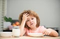 Unhappy child sit at table at home kitchen have no appetite. Caucasian toddler child boy eating healthy soup in the Royalty Free Stock Photo