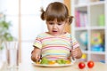 Unhappy child sitting at breakfast and uncertainty