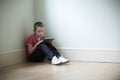 Unhappy Child Sitting In Room With Digital Tablet Royalty Free Stock Photo
