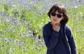 Unhappy child with sunglasses thinking, seeking for inspiration, cornflower field