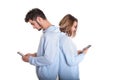 Unhappy couple backwards with their mobile phones typing isolated Royalty Free Stock Photo