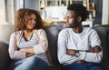 Unhappy couple talking about a breakup or problems in their relationship while sitting on a sofa at home together Royalty Free Stock Photo